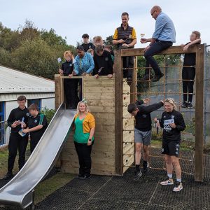 Children & Teachers On And By Climbing Frame